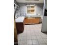 Dated kitchen with wood cabinets, tile flooring, and a double sink at 3510 W Seldon Ln, Phoenix, AZ 85051