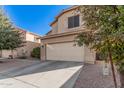 Two-story house with tan exterior, attached garage, and landscaping at 3621 W Glass Ln, Phoenix, AZ 85041