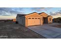 Tan house with a two-car garage and desert landscaping at 5403 S 360 Th Ave, Tonopah, AZ 85354