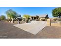 Long driveway leading to a tan house with landscaping at 6416 W Parkside Ln, Glendale, AZ 85310