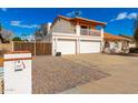 Inviting two-story home features a three-car garage, balcony, and gated driveway for added privacy at 6422 W Garden Dr, Glendale, AZ 85304