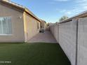 Side yard with artificial turf and block wall at 7668 E Thunderhawk Rd, Scottsdale, AZ 85255