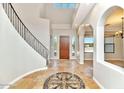 Grand foyer with decorative tile work, curved staircase, and arched doorways with exterior views at 817 E Irvine Rd, Desert Hills, AZ 85086