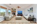 Comfortable living room with a stone fireplace, large windows, and stylish neutral furnishings at 817 E Irvine Rd, Desert Hills, AZ 85086