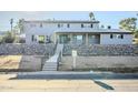 Two-story house with gray siding, stone wall, and a wood-framed entryway at 925 W Fairway Dr, Mesa, AZ 85201