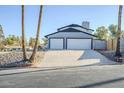 Two-car garage with white doors and a sloped driveway at 925 W Fairway Dr, Mesa, AZ 85201