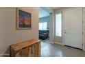 Bright entryway with tile flooring, wooden cabinet, and view to living room at 10834 W Swayback Pass, Peoria, AZ 85383