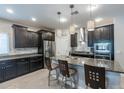 Spacious kitchen with dark cabinets, granite counters, and island at 10834 W Swayback Pass, Peoria, AZ 85383