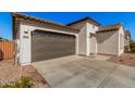 Two-car garage with brown doors and a long driveway at 17022 W Echo Ln, Waddell, AZ 85355