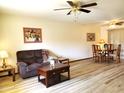 Living room featuring hardwood floors, a brown couch and a coffee table at 19002 N Signal Butte Cir, Sun City, AZ 85373