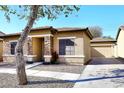 Tan house with stone accents, attached garage, and a landscaped front yard at 234 N Seymour --, Mesa, AZ 85207