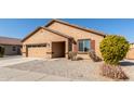 Tan house with a two-car garage and a landscaped yard at 25360 W Fremont Ct, Buckeye, AZ 85326