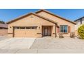 Tan house with a two-car garage and desert landscaping at 25360 W Fremont Ct, Buckeye, AZ 85326