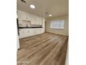 Kitchen with white cabinets, laminate flooring, and modern appliances at 2611 N 40Th Ave, Phoenix, AZ 85009