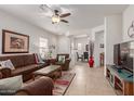 Living room with tile floors, brown sofas, and views into dining area at 26236 W Wahalla Ln, Buckeye, AZ 85396