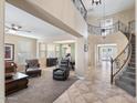 Grand foyer with a winding staircase, tile flooring, and views into the living and dining areas at 3115 E Turnberry Dr, Gilbert, AZ 85298