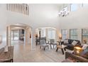 Open concept living area with high ceilings, dining area, and view into kitchen at 8147 W Hilton Ave, Phoenix, AZ 85043