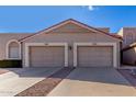 Front view of two-car garage and tan stucco home at 9183 W Century Dr, Arizona City, AZ 85123