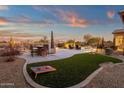 Outdoor entertaining area with artificial turf, bar, and cornhole at 19771 N 84Th Way, Scottsdale, AZ 85255