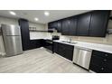 Tastefully updated kitchen boasts black cabinets, stainless steel appliances, and light countertops, creating a modern culinary space at 1983 E Don Carlos Ave, Tempe, AZ 85281