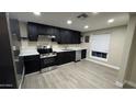 An updated kitchen space features sleek black cabinets, stainless steel appliances, and light wood-look flooring at 1983 E Don Carlos Ave, Tempe, AZ 85281