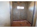 Close-up of a shower space with patterned tile work and a small window for natural light at 28551 N 257Th Ave, Wittmann, AZ 85361