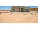 A light green home with a stone accent wall in a desert setting, awaiting landscaping at 28583 N 257Th Dr, Wittmann, AZ 85361