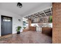 Covered front porch with tiled flooring, brick accents, and charming decor at 545 W Windsor Ave, Phoenix, AZ 85003
