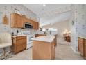 Kitchen features wood cabinets, an island, and white appliances at 7589 W Claremont St, Glendale, AZ 85303