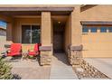 Covered entryway with stone accents and red chairs at 105 S 224Th Ave, Buckeye, AZ 85326