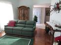 Living room with green sofa and wooden cabinet at 16809 N Meadow Park Dr, Sun City, AZ 85351