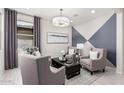 Cozy sitting area with gray armchairs and geometric accent wall at 18173 W Cielo Grande Ave, Surprise, AZ 85387