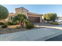 Two-story home with a brown garage door and nicely landscaped yard at 21720 N 265Th Dr, Buckeye, AZ 85396