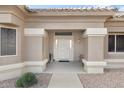 Front entrance with a light-colored door and a small bench at 22915 N Wagon Wheel Dr, Sun City West, AZ 85375