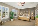 Bright bedroom with a post bed and plantation shutters at 23313 N De La Guerra Ct, Sun City West, AZ 85375