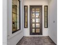 Modern entryway with a black framed glass front door and tile flooring at 2553 E Virginia Cir, Mesa, AZ 85213