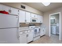 A bright kitchen with white cabinets, granite countertops, and appliances at 3270 S Goldfield Rd # 816, Apache Junction, AZ 85119