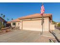 Single-story home with desert landscaping, two-car garage, and American flag at 6331 S Cypress Point Dr, Chandler, AZ 85249