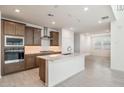 Modern kitchen with island, stainless steel appliances and dark wood cabinets at 7419 W Whitehorn Trl, Peoria, AZ 85383