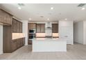 Bright kitchen features an island, stainless steel appliances, and dark wood cabinets at 7419 W Whitehorn Trl, Peoria, AZ 85383