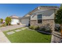 House exterior with stone facade and a well-maintained lawn at 12059 N Luckenbach St, Surprise, AZ 85388