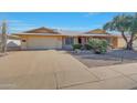 Brick ranch house with a two-car garage and nicely landscaped front yard at 13226 W Mesa Verde Dr, Sun City West, AZ 85375