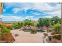 Expansive backyard featuring a refreshing pool with rock accents, mature trees, and picturesque mountain views at 15701 E Greystone Dr, Fountain Hills, AZ 85268