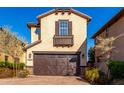 Tan three-story home with brown garage doors, shutters, and balcony at 15913 S 11Th Way, Phoenix, AZ 85048