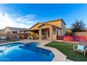 Inviting backyard oasis featuring a sparkling pool, covered patio, and lush landscaping at 1625 W Cool Water Way, San Tan Valley, AZ 85144