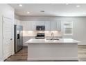 Modern kitchen with white cabinets, quartz countertops, and stainless steel appliances at 17741 W Mission Ln, Waddell, AZ 85355