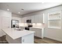 Modern kitchen with white cabinets, quartz countertops, and stainless steel appliances at 17741 W Mission Ln, Waddell, AZ 85355