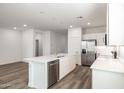 Modern kitchen with island, white cabinets, and stainless steel appliances at 17741 W Mission Ln, Waddell, AZ 85355