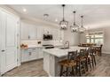 Modern kitchen featuring white cabinets, island, and stainless steel appliances at 18610 W Alice Ave, Waddell, AZ 85355