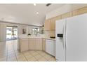 The kitchen boasts tile floors, white appliances, wood cabinets, and an open view to the living room at 23114 N 146Th Dr, Sun City West, AZ 85375